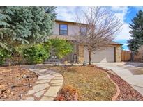 Charming two-story home with brick and siding exterior, mature trees, and a stone walkway at 603 E Long Ct, Littleton, CO 80122