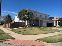 Charming two-story home with a well-manicured lawn, mature tree, and a welcoming covered front porch at 20292 E 47Th Ave, Denver, CO 80249