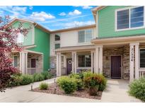 Inviting exterior featuring stone accents, colorful siding, and manicured landscaping at 21528 E 59Th Pl, Aurora, CO 80019