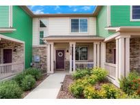 Charming two-story townhome with inviting front porch and nicely landscaped front yard at 21528 E 59Th Pl, Aurora, CO 80019