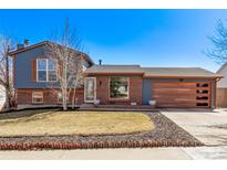 Charming two-story home with a brick and blue wood exterior and a beautifully landscaped front yard at 19228 E Arizona Pl, Aurora, CO 80017