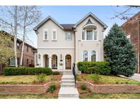 Charming two-story home features arched entryway, manicured lawn, and mature landscaping at 1164 S High St, Denver, CO 80210