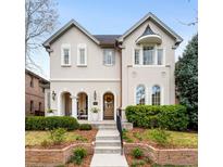 Elegant two-story home featuring a charming facade, arched entryway, manicured landscaping, and inviting staircase at 1164 S High St, Denver, CO 80210