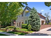 Beautiful exterior view of home featuring mature landscaping, stone accents, and arched entryways at 1164 S High St, Denver, CO 80210