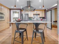 Modern kitchen boasts stainless appliances, center island with seating, and unique backsplash at 1449 Wynkoop St # 305, Denver, CO 80202