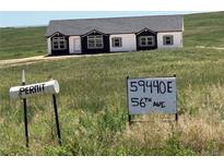 New construction exterior showing black and white paint scheme with sign in the foreground at 59440 E 56Th Ave, Strasburg, CO 80136