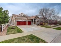 Charming exterior with stone accents, red garage doors, and a well-manicured lawn at 21270 E Eldorado Dr, Aurora, CO 80013