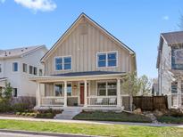Charming two-story home featuring a welcoming front porch and well-maintained lawn at 5511 Wabash St, Denver, CO 80238