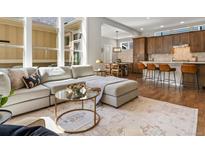 Bright, open living room with a comfortable sectional sofa and large windows at 5511 Wabash St, Denver, CO 80238