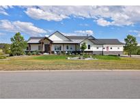 Beautiful two-story home with a green lawn, lovely landscaping, and a charming covered entryway at 2705 Fox View Trl, Franktown, CO 80116