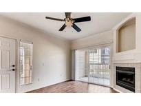 Bright living room featuring wood floors, ceiling fan, and sliding glass doors to a private patio at 10165 E Carolina Pl # 102, Aurora, CO 80247
