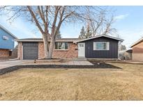 Brick ranch home with updated dark gray siding, landscaping, and a spacious yard at 12516 E Alaska Ave, Aurora, CO 80012
