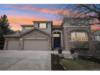 Charming two-story stone home featuring a three-car garage and a covered front entry at 423 N Snowmass Cir, Superior, CO 80027