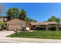 Charming single-story home featuring a manicured lawn, attached garage, and inviting curb appeal at 8228 Marshall Ct, Arvada, CO 80003
