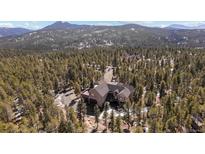 Expansive property with a sprawling home nestled amongst lush forest and mountain views at 11421 Belle Meade Dr, Conifer, CO 80433