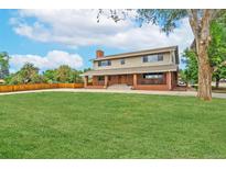 Charming two-story home with brick accents, mature trees, and a well-maintained lawn at 10101 W 72Nd Ave, Arvada, CO 80005