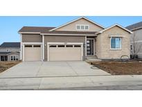 Two-story home featuring a three-car garage, stone facade, and modern architectural details at 6966 E 126Th Pl, Thornton, CO 80602