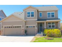 Charming two-story home with a two-car garage and a welcoming front porch, featuring beautiful stone accents and a well-manicured lawn at 7258 Oasis Dr, Castle Rock, CO 80108