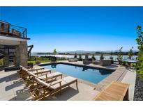 Luxury pool and patio with mountain views, lounge chairs and fire pit at 2599 Heron Lakes Pkwy, Berthoud, CO 80513