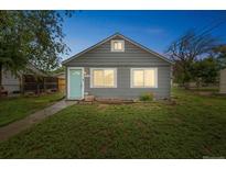 Charming home with a blue door and well maintained yard at 6104 Hudson St, Commerce City, CO 80022