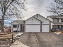 Charming home featuring a two car garage, stone accents, and well-maintained landscaping at 19301 E Tufts Cir, Centennial, CO 80015