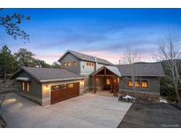 Charming home with a three-car garage, inviting front entrance, and a well-maintained concrete driveway at 1055 Divide View Dr, Golden, CO 80403