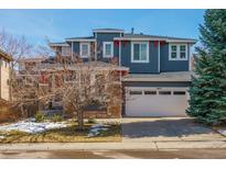 Charming two-story home features a two-car garage, red accents, and meticulous landscaping at 10819 Mountshire Cir, Highlands Ranch, CO 80126