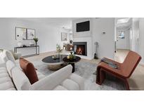 Bright living room featuring a fireplace and light wood floors at 264 S Newark Cir, Aurora, CO 80012