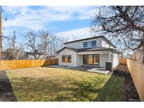 A spacious backyard featuring a well-maintained lawn and a modern home with a patio area at 3041 S Bellaire S St, Denver, CO 80222