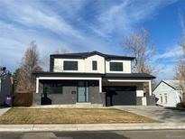 Modern two-story home featuring a dark gray brick front and white siding accents, topped by a sleek black roof and trim at 3041 S Bellaire S St, Denver, CO 80222