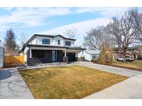 Charming two-story home features black brick accents, modern design, a well kept lawn, and an attached two car garage at 3041 S Bellaire S St, Denver, CO 80222