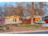 Charming single story home boasts a landscaped front yard, detached garage and an appealing brick accent wall at 2370 S Meade St, Denver, CO 80219