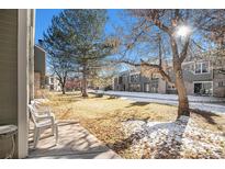 Sunny backyard with trees and pathways, showing a common area at 3445 S Ammons St # 15-4, Lakewood, CO 80227