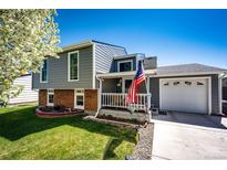 Charming two-story home featuring gray siding, brick accents, and a welcoming front porch at 862 Centennial Way, Bennett, CO 80102