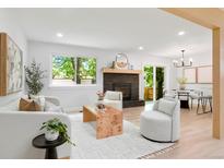 Bright living room featuring a modern fireplace, light wood floors, and ample natural light at 202 Hoover Ave, Louisville, CO 80027