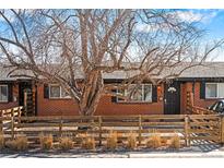 Charming brick home with a lovely front yard and beautiful mature trees providing shade at 5140 W 9Th Ave, Denver, CO 80204