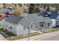 Charming home featuring a well-maintained exterior and a tidy front yard with chain link fence at 1104 Miner St, Idaho Springs, CO 80452