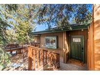 Charming home entrance featuring a wooden porch, green door and mature trees at 838 Lakeshore Dr, Boulder, CO 80302