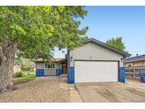 Charming home featuring attached garage, neutral siding, and blue accents at 5222 Xanadu St, Denver, CO 80239