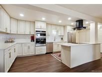 Bright kitchen features custom cabinetry, stainless appliances, and a center island at 7255 E Quincy Ave # 404, Denver, CO 80237