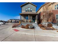 Charming two-story home featuring a covered front porch with seating and landscaped front yard at 12705 Ulster St, Thornton, CO 80602