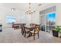 Bright dining room features a modern chandelier, sliding glass doors to a balcony, and neutral carpeting at 9530 E Florida Ave # 2001, Denver, CO 80247