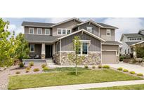 Charming two-story home featuring stone accents, a covered porch, and a well-maintained front yard at 27653 E Euclid Dr, Aurora, CO 80016