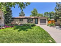 Charming brick ranch-style home with lush green lawn and meticulously landscaped front yard at 5525 E Bails Dr, Denver, CO 80222