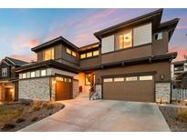Stunning modern home featuring stone accents, a two-car garage, and professional landscaping at 16370 Graham Peak Way, Broomfield, CO 80023