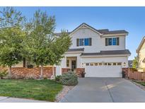 Charming two-story home with red brick accents, green lawn, and a well-maintained yard at 11013 Valleybrook Cir, Highlands Ranch, CO 80130