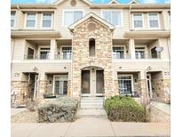 Multi-story townhouse featuring stone accents, multiple balconies, and tandem entry doors at 1509 S Florence Ct # 218, Aurora, CO 80247