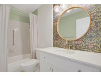 Bright bathroom featuring stylish wallpaper, modern vanity, and a shower with tub at 14001 E Marina Dr # 603, Aurora, CO 80014