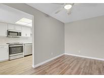 Bright living room featuring hardwood-style floors leading into an updated kitchen at 14001 E Marina Dr # 603, Aurora, CO 80014