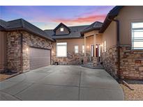 Beautiful home featuring a stone and stucco exterior, three-car garage, and covered front porch at 6532 S Tempe St, Aurora, CO 80016